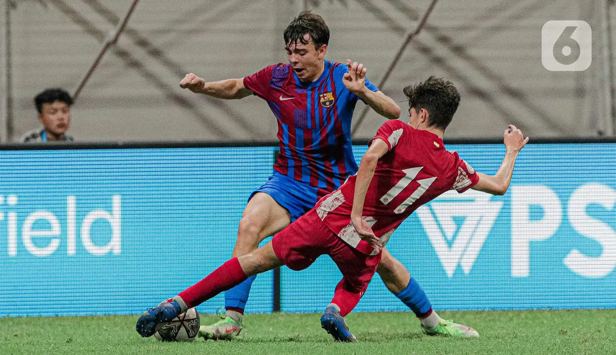 Pemain Altetico Madrid U-18 Diego Del Castillo Alonso (kanan) menghalau pemain Barcelona U-18 pada pertandingan International Youth Championship (IYC) 2021 di Jakarta International Stadium (JIS), Jakarta, Selasa (19/4/2022). Barcelona U-18 menang 1-0. (Liputan6.com/Faizal Fanani)