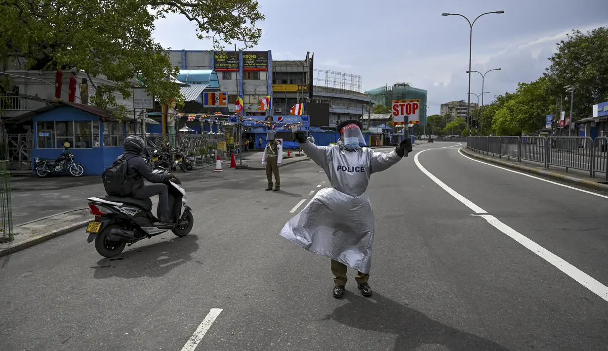 Seorang polisi memberi isyarat kepada pengendara di jalan setelah pemerintah memberlakukan pembatasan perjalanan dan lockdown akhir pekan di Kolombo, Sri Lanka, Sabtu (22/5/2021). Sri Lanka pada Jumat, 21 Mei mencatat 3.547 kasus harian corona Covid-19. (Ishara S. KODIKARA/AFP)