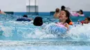 Seorang anak bermain di kolam renang di sebuah taman hiburan di Tokyo, Jepang (19/7). Badan Meteorologi Jepang mengumumkan Jepang tengah, termasuk Tokyo, telah menyelesaikan musim hujan 'Tsuyu'.  (AFP Photo/Toshifumi Kitamura)