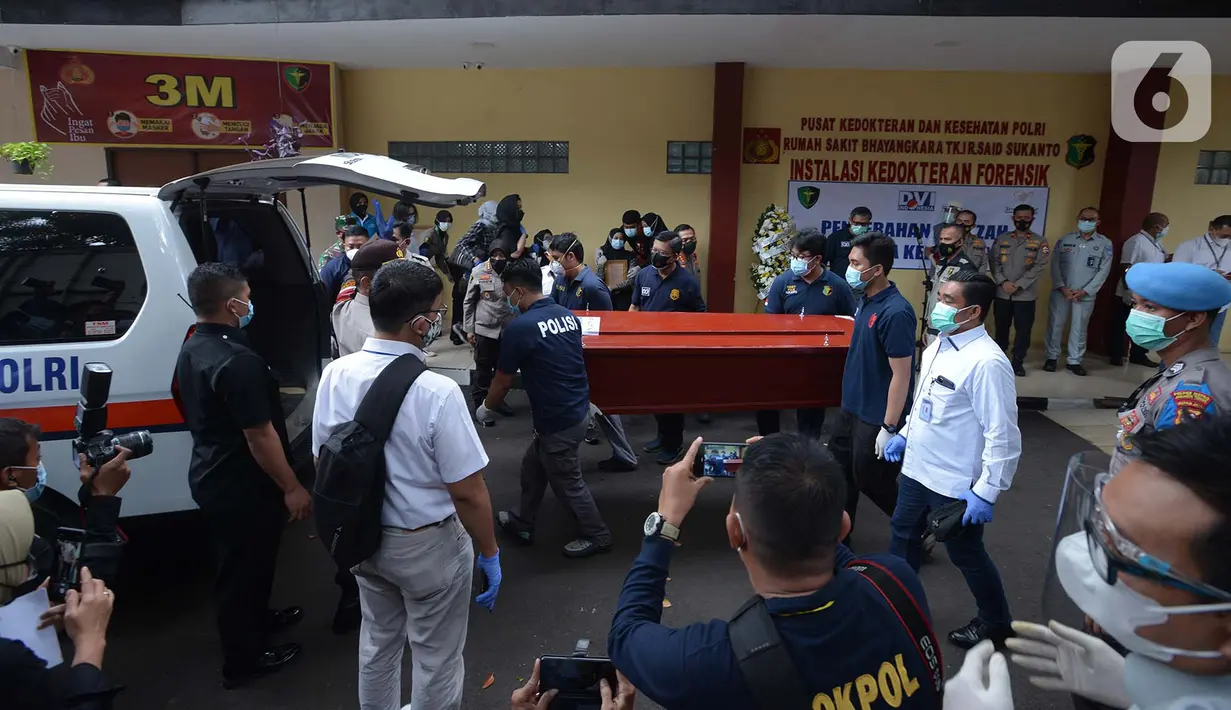 Petugas membawa peti jenazah berisi korban kecelakaan Sriwijaya Air SJ 182 atas nama Okky Bisma menuju mobil ambulans saat serah terima kepada pihak keluarga di RS Polri, Jakarta, Kamis (14/1/2021). Okky Bisma menjadi korban pertama yang berhasil teridentifikasi. (merdeka.com/Imam Buhori)