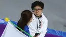 Peraih medali emas, skater Nao Jepang Kodaira memeluk dan memberikan dukungan kepada skater Korsel Lee Sang Hwa yang menangis tersedu karena hanya mendapatkan medali perak di Olimpiade Musim Dingin Pyeongchang 2018, Minggu (18/2). (AP/Eugene Hoshiko)