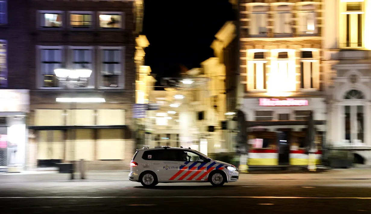 Sebuah mobil polisi Belanda berpatroli di jalan-jalan sepi Den Bosch selama jam malam, pada 26 Januari 2021, sehari setelah polisi bentrok dengan sekelompok demonstran yang memprotes penerapan langkah-langkah baru, termasuk jam malam, untuk melawan penyebaran Covid-19. . (AFP/Kenzo Tribouillard)