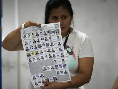 Seorang petugas pemilu menunjukkan surat suara saat penghitungan suara dimulai setelah pemungutan suara ditutup selama pemilihan umum di Guatemala City, Minggu, 25 Juni 2023. (AP Photo/Moises Castillo)