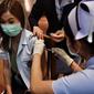 Seorang petugas kesehatan menerima vaksin Covid-19 CoronaVac dari Sinovac, di Institut Penyakit Menular Bamrasnaradura di Bangkok, Minggu (28/2/2021). Meski tertinggal diantara negara-negara Asia Tenggara lainnya, akhirnya Thailand memulai kampanye vaksin COVID-19. (Lillian SUWANRUMPHA/AFP)