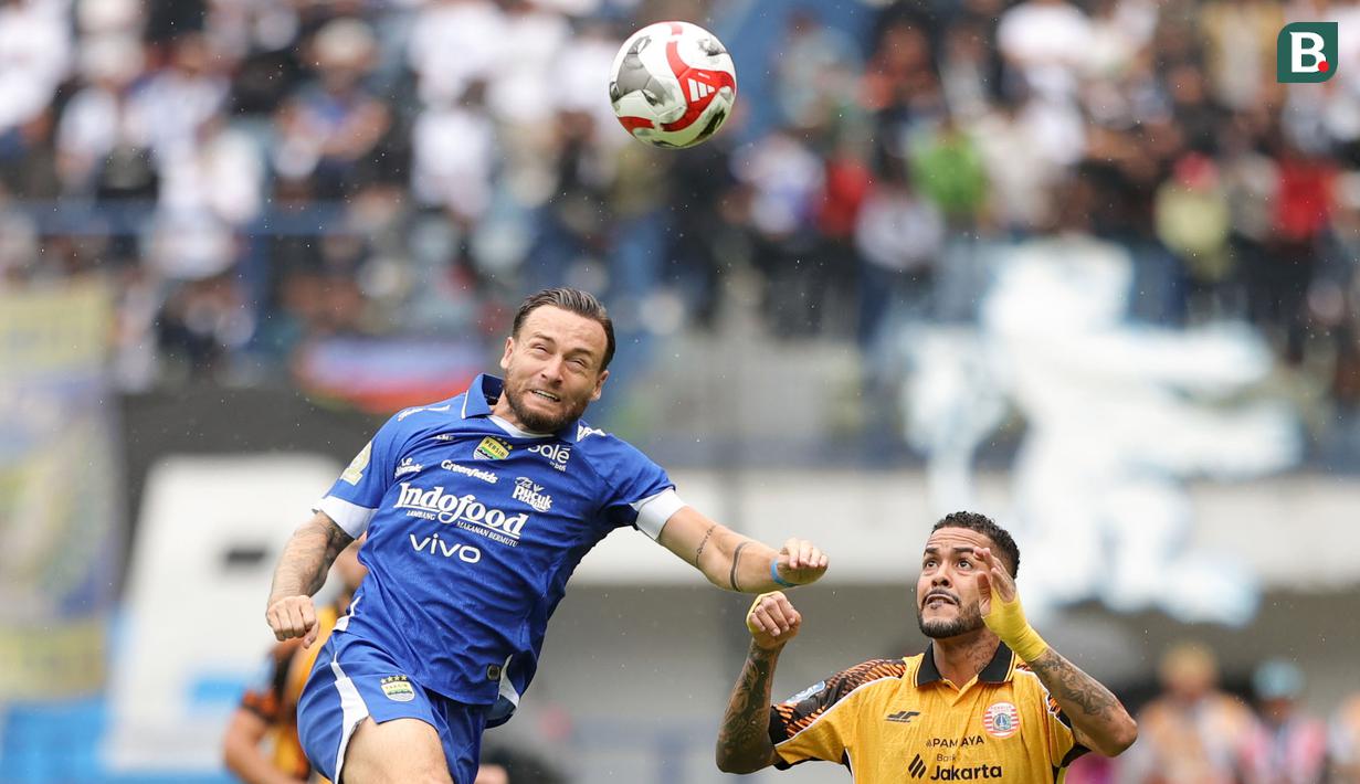 Pemain Persib Bandung, Marc Klok (kiri) berebut bola dengan pemain Persija Jakarta, Maxwell dalam laga lanjutan BRI Super League 2025/2026 melawan Persija Jakarta di Stadion Gelora Bandung Lautan Api, Bandung, Minggu (11/01/2026). (Bola.com/Abdul Aziz)