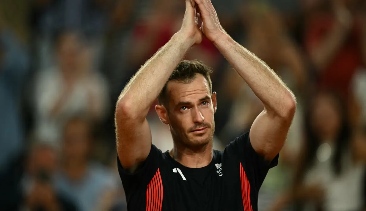 Petenis Inggris Andy Murray mengucapkan selamat tinggal setelah bermain dengan Daniel Evans melawan petenis Amerika Taylor Fritz dari AS dan Tommy Paul pada babak perempat final nomor ganda putra tenis Olimpiade Paris 2024 di Court Suzanne-Lenglen di Stadion Roland-Garros, Kamis (1/8/2024). (CARL DE SOUZA / AFP)