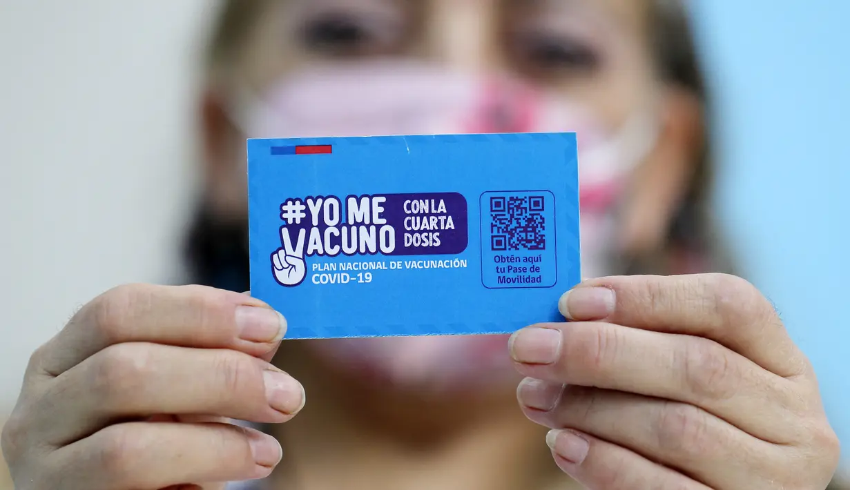Seseorang menunjukkan kartu vaksinasi COVID-19 di pusat vaksinasi di Santiago, Chile, Senin (10/1/2022). Chile mulai memberikan dosis keempat vaksin COVID-19 kepada warga berusia di atas 12 tahun yang mengalami gangguan kekebalan. (Javier TORRES / AFP)