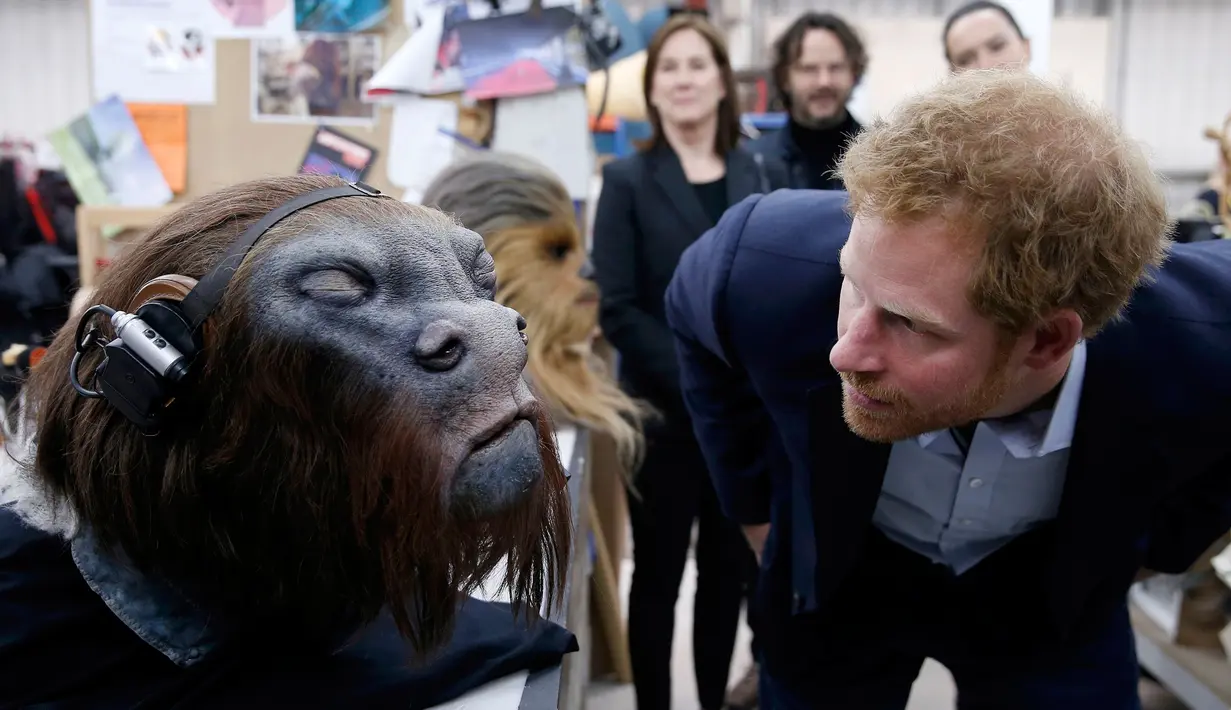 Pangeran Harry mengamati topeng robot saat berkunjung ke studio pembuatan film Star Wars di Pinewood Studios, London, (19/4). Pangeran William dan Harry berkeliling Pinewood untuk mengunjungi workshop produksi film Star Wars (REUTERS/Adrian Dennis/Pool)