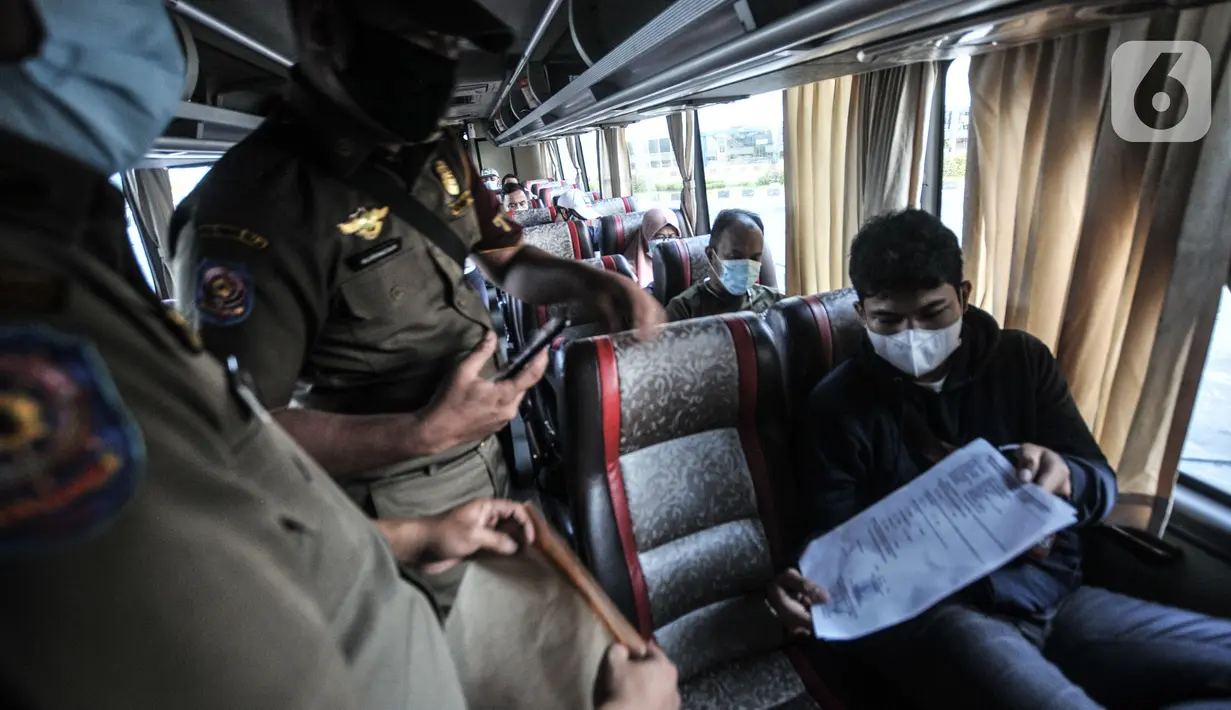 Petugas memeriksa dokumen dan SIKM penumpang sebelum berangkat dari Terminal Pulogebang, Senin (10/5/2021). Petugas Terminal Pulogebang mencatat hingga sore ini terdapat 16 penumpang dan 4 bus AKAP yang berangkat dengan tujuan kota-kota di Jawa Tengah, Timur dan Madura. (merdeka.com/Iqbal S Nugroho)