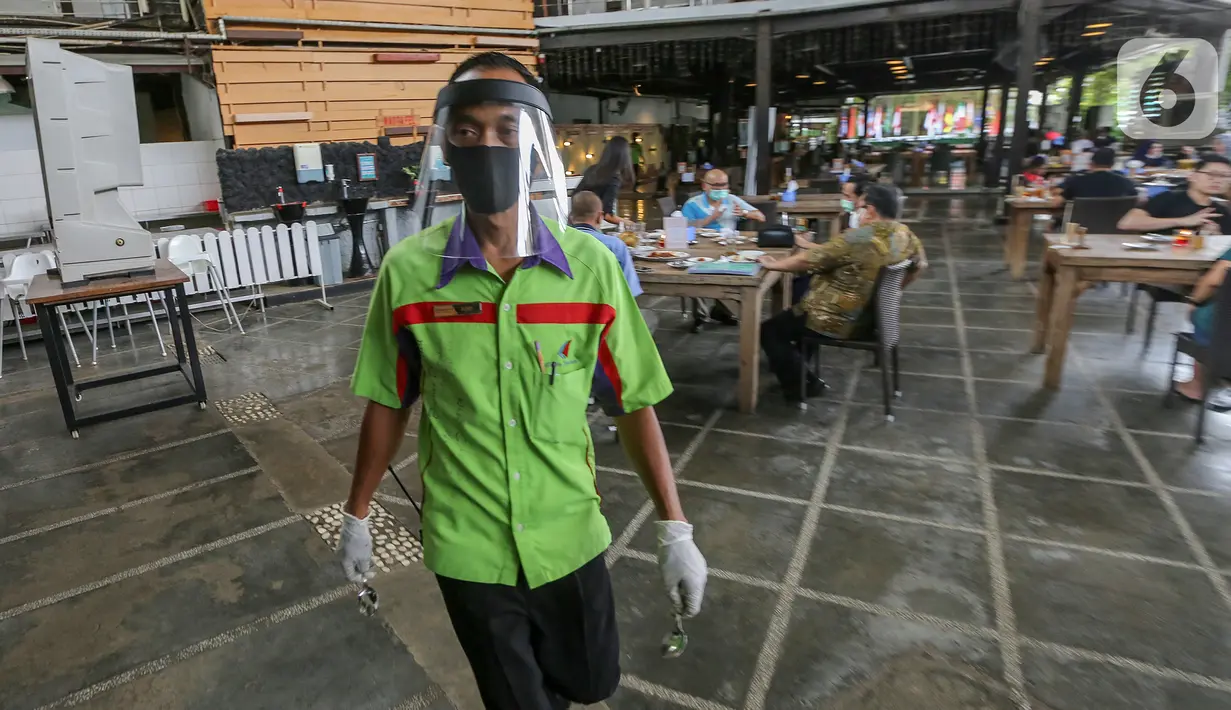Pramusaji lengkap dengan APD berupa face shield, sarung tangan dan masker berjalan di Restoran Bandar Djakarta, Alam Sutera, Tangerang Selatan, Rabu (10/6/2020). Sebelum pemberlakuan new normal restoran ini kembali buka dengan menerapkan protokol kesehatan. (Liputan6.com/Fery Pradolo)
