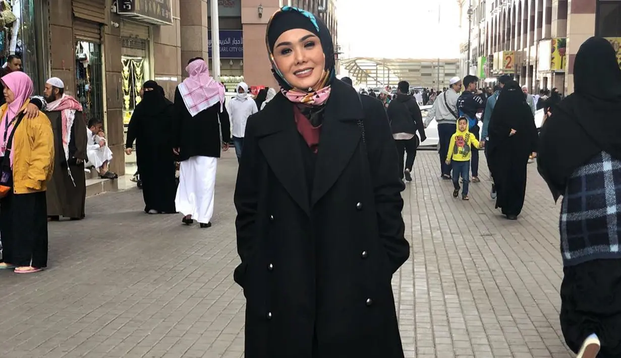 Yuni Shara tampak memesona mengenakan hijab bernuansa warna hitam dengan motif simpel. Coat berwarna hitam menambah kesan anggun dari dari ibu dua anak ini. Begini gaya Yuni saat menikmati indahnya kota Madina.(Liputan6.com/IG/@yunishara36)