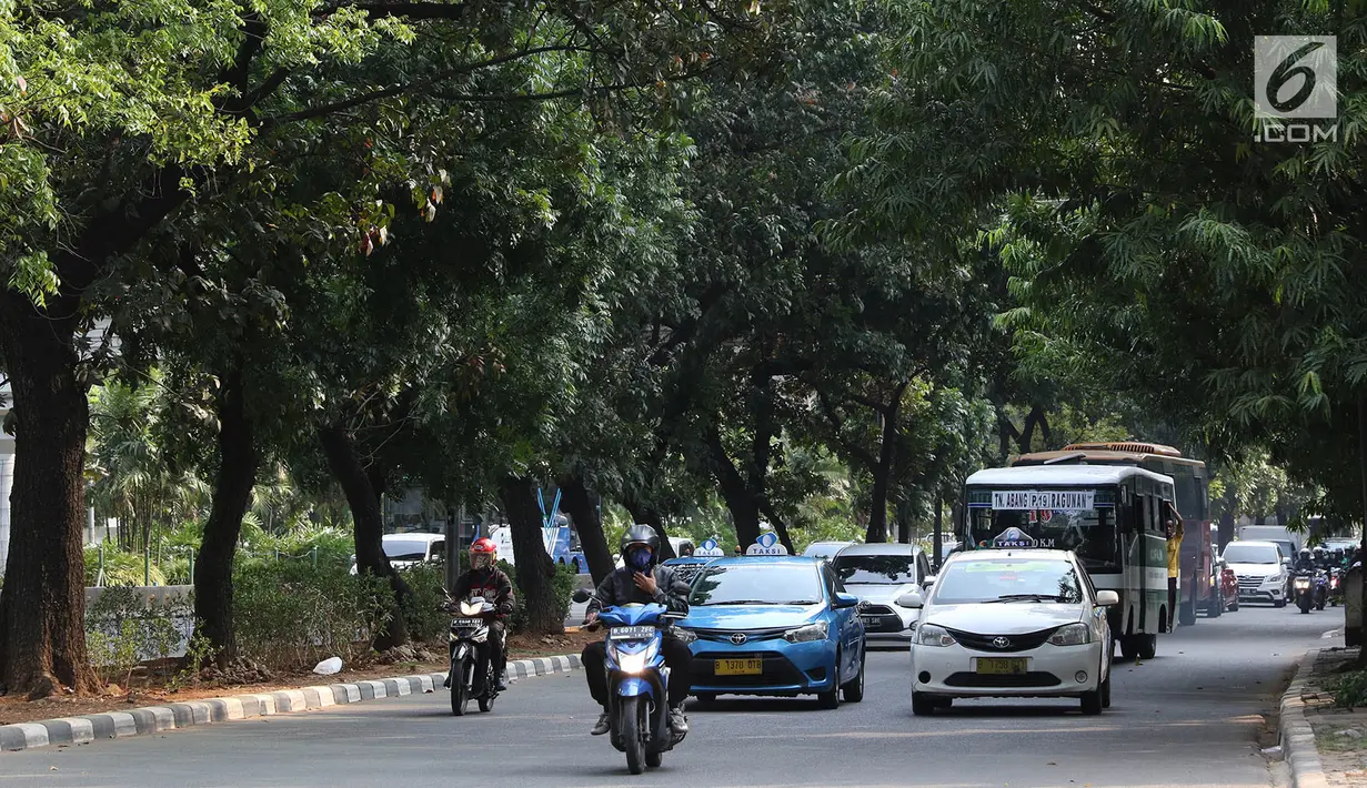 Kendaraan melintas di Jalan Sudirman, Jakarta, Selasa (19/9). Terkait pembangunan trotoar, Sekda DKI Saefullah mengatakan ribuan pohon akan dipindahkan ke lokasi yang merupakan aset Pemprov DKI, seperti Taman BMW. (Liputan6.com/Immanuel Antonius)