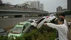 Orang-orang melihat mobil-mobil yang terendam banjir setelah hujan lebat melanda Zhengzhou di provinsi Henan, Kamis (22/7/2021). Henan, provinsi terbesar ketiga di China, yang merupakan rumah bagi sekitar 94 juta orang, telah dilanda badai hujan yang tidak biasa sejak akhir pekan. (Noel Celis/AFP)