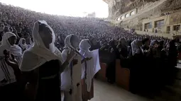 Ribuan umat berdoa saat menghadiri acara Minggu Palma di Biara Samaan, gunung Mokattam, Kairo , Mesir , (24/4).Meski berada di lereng gunung, tak menyurutkan para jemaat untuk mengikuti kegiatan ibadah di tempat ini. (REUTERS / Amr Abdallah Dalsh)