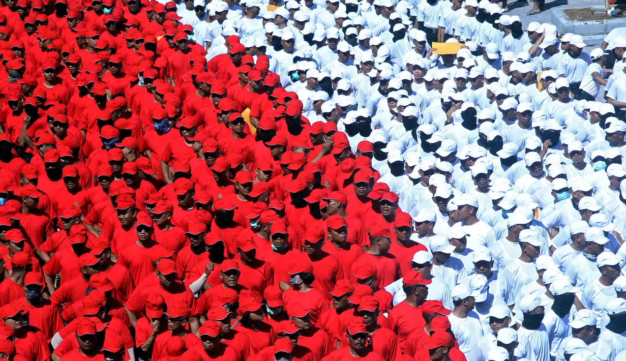 Anggota polisi membentuk formasi merah putih saat pengibaran Bendera Merah Putih terpanjang di Pantai Pandawa, Badung, Bali, Senin (14/8). Kegiatan itu memecahkan rekor MURI sebagai pembentangan Merah Putih terpanjang di tebing (AP Photo/Firdia Lisnawati)