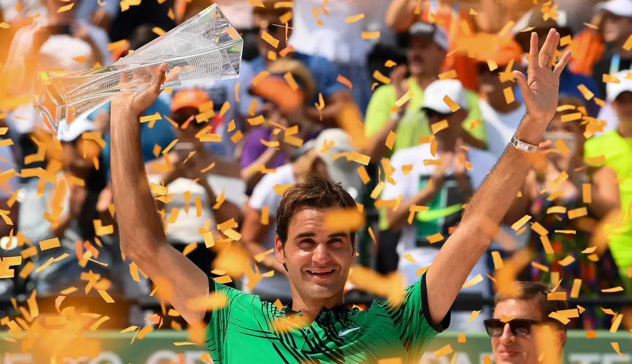 Petenis Swiss, Roger Federer mengangkat tropi usai memenangkan pertandingan pada final Miami Terbuka di Crandon Park, Florida (2/4). Federer menundukkan rival lamanya, Rafael Nadal dua set langsung 6-3, 6-4. (Rob Foldy / Getty Images / AFP)