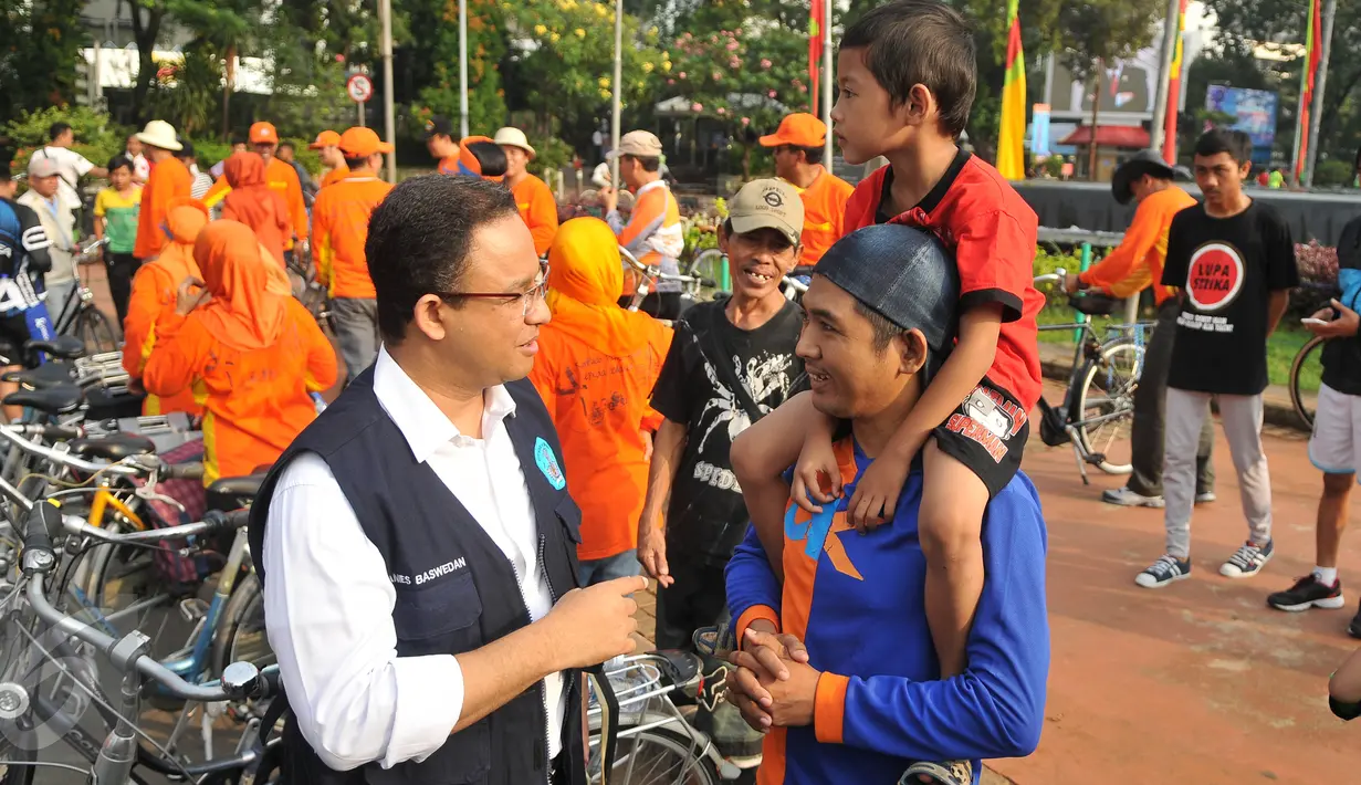 Mendikbud Anies Baswedan menyapa warga dan anaknya pada Car Free Day di kawasan Thamrin, Jakarta, Minggu (17/7). Anies mengkampanyekan imbauan kepada orangtua untuk mengantarkan anak sekolah pada hari pertama masuk sekolah. (Liputan6.com/Gempur M Surya)