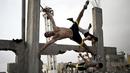 Anggota Bar Palestine, berlatih Street workout di bekas reruntuhan bangunan di kota Gaza, Palestina. Street workout adalah latihan yang dilakukan di luar ruang dengan memanfaatkan fasilitas yg ada. (AFP Photo/Mohammed Abed)