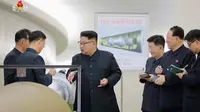 Pemimpin Korut, Kim Jong-un berbincang dengan para peneliti mengenai program senjata nuklir saat meninjau pembuatan bom hidrogen yang dapat dimasukkan ke dalam rudal balistik antarbenua pada 3 September 2017. (KRT via AP Video)