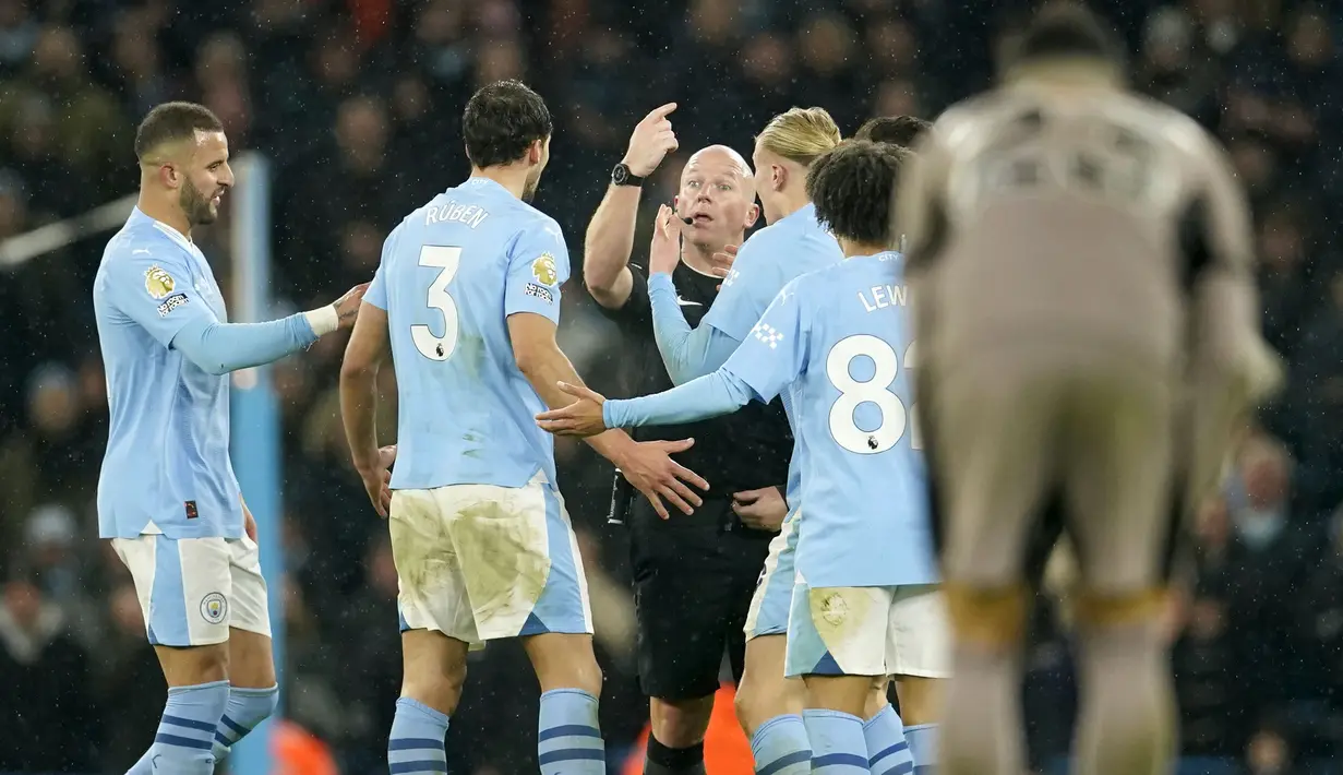 Wasit Simon Hooper (tengah) memberikan penjelasan kepada sejumlah pemain Manchester City saat laga pekan ke-14 Liga Inggris 2023/2024 melawan Tottenham Hotspur yang berlangsung di Etihad Stadium, Manchester, Inggris, Senin (04/12/2023) dini hari WIB. (AP Photo/Dave Thompson)
