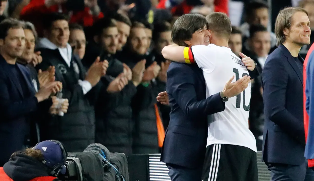 Penyerang Jerman, Lukas Podolski memeluk pelatihnya Joachim Loew saat pertandingan persahabatan melawan Inggris di Dortmund, (23/3). Podolski melakukan 130 penampilan bersama Die Mannschaft. (AP Photo/Frank Augstein)