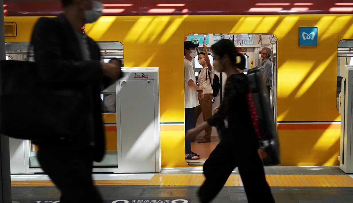 Orang-orang yang memakai masker untuk mencegah penyebaran virus corona COVID-19 berjalan di sebuah stasiun kereta api di Tokyo, Jepang, Kamis (2/7/2020). Jepang mengangkat darurat pandemi selama tujuh minggu pada akhir Mei. (AP Photo/Eugene Hoshiko)