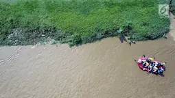 Peserta dengan perahu karet menyusuri Sungai Ciliwung sambil membersihkan sampah pada acara Bersih-Bersih Sungai Ciliwung, Jakarta, Minggu (08/4). Sebanyak 34 perahu karet dikerahkan menempuh perjalanan sepanjang 11 kilometer. (Liputan6.com/Fery Pradolo)