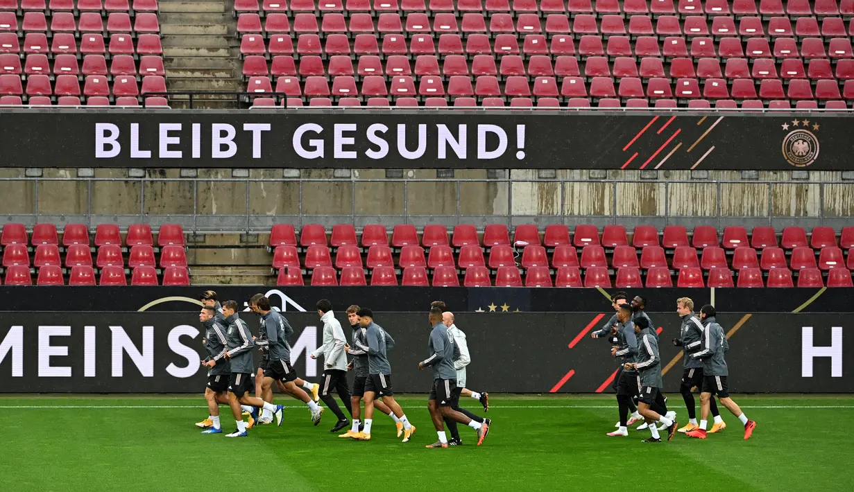 Para pemain timnas Jerman melakukan pemanasan saat sesi latihan di stadion Rheinenergie di Cologne, Jerman barat (9/10/2020). Jerman akan bertanding melawan Turki pada laga persahabatan di stadion Rheinenergie di Cologne, Jerman, Kamis (8/10/2020). (AFP/Ina Fassbender)