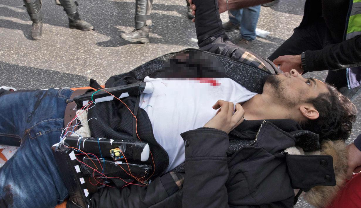 Seorang pria Palestina yang dicurigai mengenakan rompi bom bunuh diri dibawa ke sebuah ambulans setelah dia ditembak polisi Israel karena menikam seorang tentara di kota al-Bireh, Tepi Barat yang diduduki Israel (15/12). (AFP Photo/Oren Ziv)