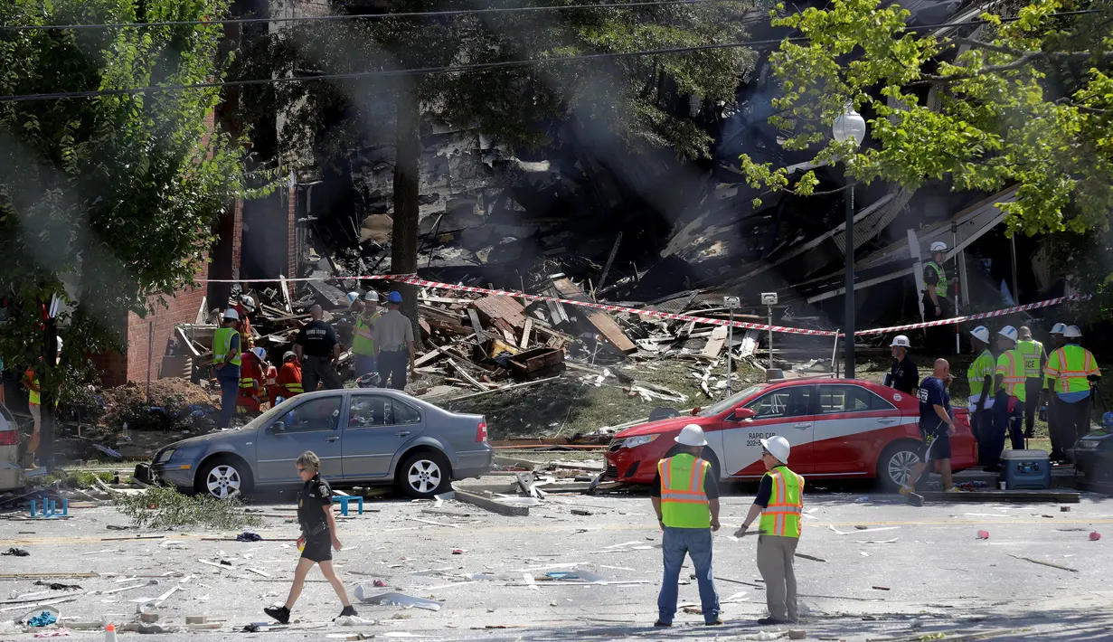 Pemadam kebakaran mengamati puing bangunan apartemen di Sivler Spring, Maryland, Washington DC, Kamis (11/8). Sedikitnya 2 orang tewas dan tujuh lainnya hilang setelah ledakan gas alam yang menyebabkan kebakaran di apartemen itu. (REUTERS/Joshua Roberts)