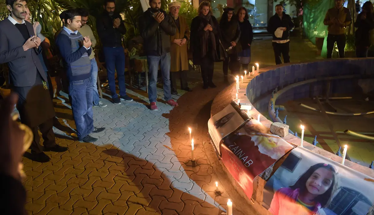 Aktivis Pakistan berdoa selama sebuah acara penghormatan untuk Zainab, yang diperkosa dan dibunuh di kota Kasur di provinsi Punjab, di Islamabad, Pakistan (11/1). Jasad Zainab diketahaui di buang ke tempat sampah. (AFP Photo/Aamir Qureshi)