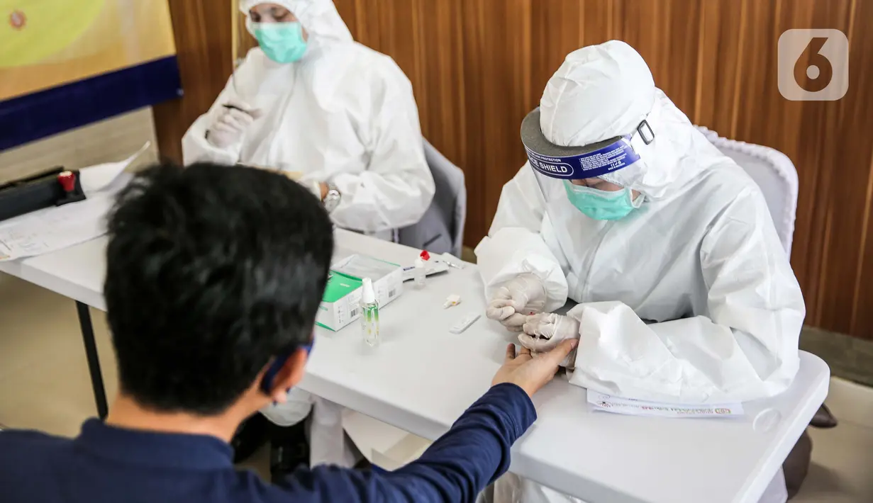 Calon penumpang melakukan rapid test di Stasiun Pasar Senen, Jakarta, Senin (27/7/2020).  PT KAI (Persero) mewajibkan penumpang untuk melakukan rapid test terlebih dahulu untuk menggunakan KA jarak jauh dengan tarif 85 ribu. (Liputan6.com/Faizal Fanani)