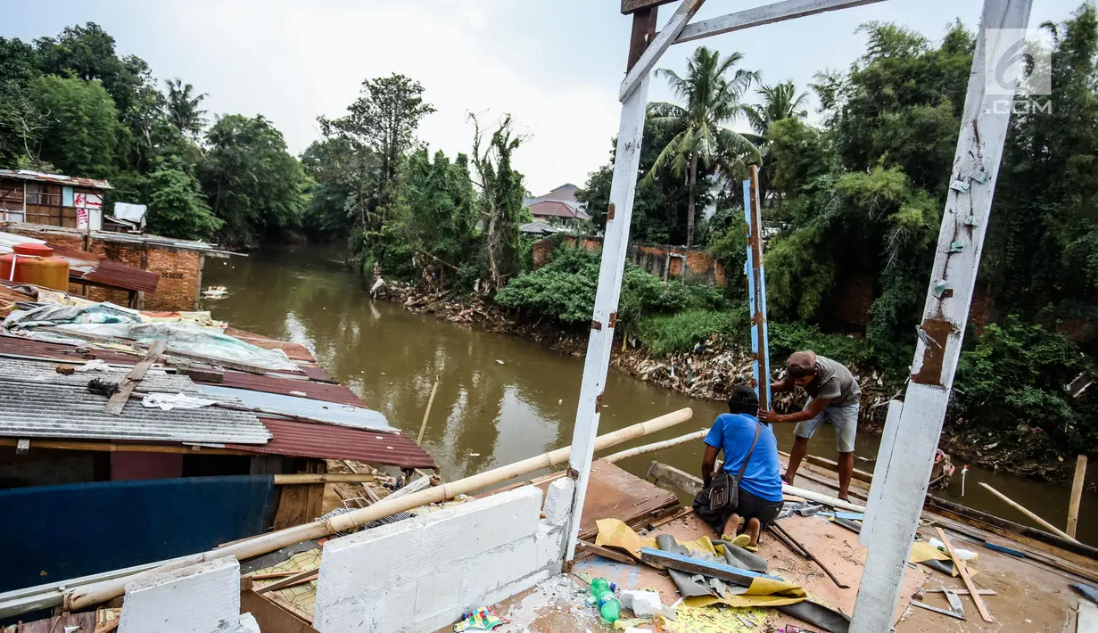 Warga mengambil bagian bangunan yang masih bisa digunakan di bantaran sungai Ciliwung, Bukit Duri, Jakarta, Rabu (5/7). Warga diharapkan sudah memindahkan barang-barangnya sebelum tiba waktu penertiban. (Liputan6.com/Faizal Fanani)