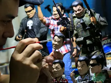 Dennis Mendoza saat menyelesaikan mainan buatannya yang merupakan karakter Presiden Filipina Rodrigo Duterte di kota Pasay , metro Manila , Filipina,(19/7). Pria 36 tahun ini menjual mainannya seharga 220 ribu hingga 1 jutaan. (REUTERS / Romeo Ranoco)