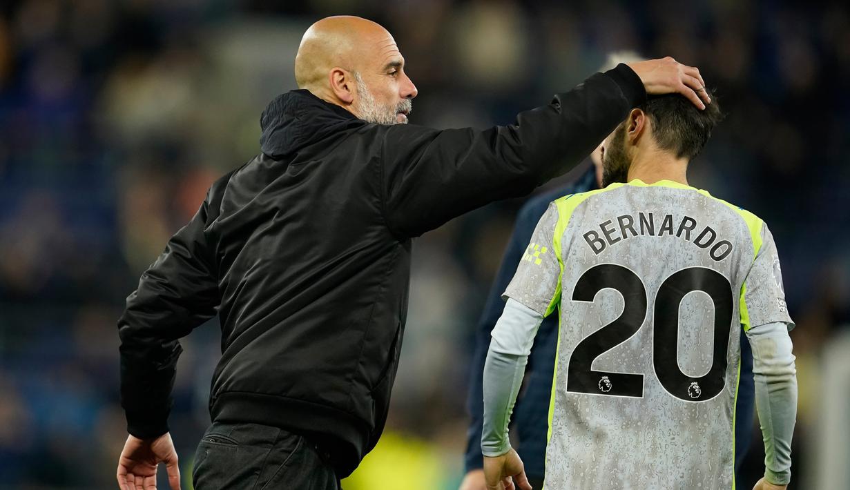 Pelatih Manchester City, Pep Guardiola, memeluk dan mencoba menenangkan Bernardo Silva usai hasil imbang 3-3 kontra Everton pada laga pekan ke-35 Premier League, Selasa (05/05/2026) dini hari WIB. (AP Photo/Dave Thompson)