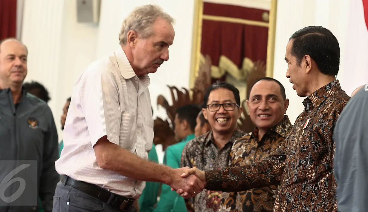 Presiden Jokowi bersalaman dengan pelatih timnas Indonesia Alfred Rield saat menyambut kedatangan rombongan timnas di Istana Merdeka, Jakarta, Senin (19/12). Jokowi mengundang pemain timnas Indonesia untuk makan siang bersama. (Liputan6.com/Faizal Fanani)