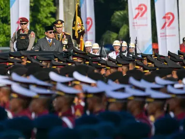 Presiden Republik Indonesia, Prabowo Subianto (tengah) didampingi Kepala Kepolisian Republik Indonesia (Kapolri) Jenderal Polisi Listyo Sigit Prabowo memeriksa pasukan saat perayaan puncak Hari Bhayangkara ke-79 yang diselenggarakan di Lapangan Monumen Nasional (Monas), Jakarta pada Selasa 1 Juli 2025. (BAY ISMOYO/AFP)