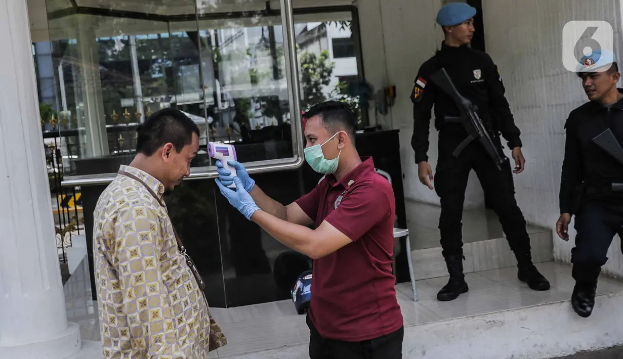 Petugas memeriksa suhu tubuh seorang pria saat akan memasuki Kompleks Istana Kepresidenan, Jakarta, Selasa (3/3/2020). Istana Kepresidenan memperketat pemeriksaan terhadap tamu, ASN, dan pejabat negara untuk mencegah penyebaran virus corona (COVID-19). (Liputan6.com/Faizal Fanani)