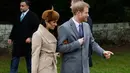 Pangeran Harry dan sang tunangan, Meghan Markle menghadiri tradisi pelayanan gereja di hari Natal Kerajaan Inggris di Sandringham, Senin (25/12). Meghan tampil cantik dengan coat krem, dipadukan tas, topi, dan kaos tangan serba coklat. (AP/Alastair Grant)