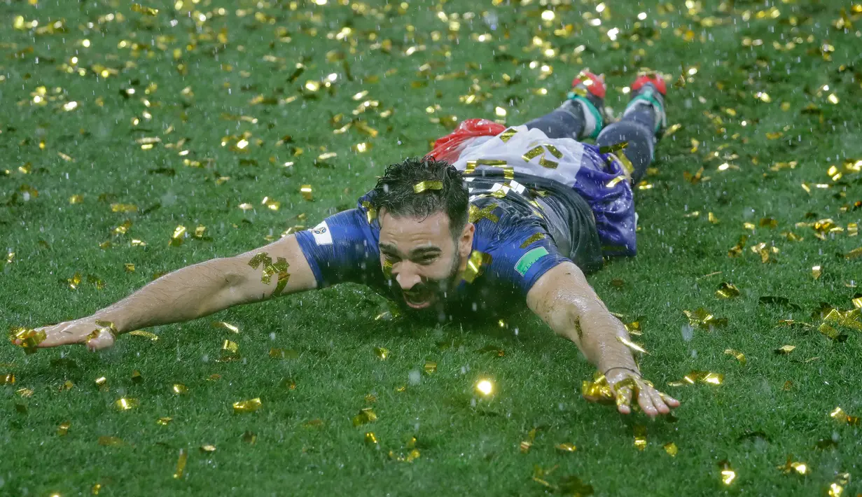 Bek Prancis, Adil Rami merayakan gelar juara Piala Dunia 2018 setelah mengalhkan Kroasia pada  laga final di Luzhniki Stadium, Minggu (15/7). Prancis berhasil menjadi juara setelah membekuk Kroasia dengan skor akhir 4-2. (AP Photo/Matthias Schrader)