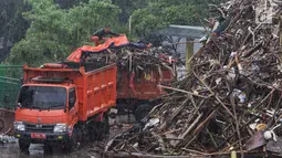 Petugas menutupi sampah yang telah dimasukkan ke dalam bak truk pengangkut di Pintu Air Manggarai, Jakarta, Rabu (24/4). Tingginya curah hujan di Bogor membuat sampah yang berasal kebanyakan dari sampah rumah tangga ini terbawa arus sungai menumpuk di Pintu Air Manggarai. (Liputan6.com/Johan Tallo)