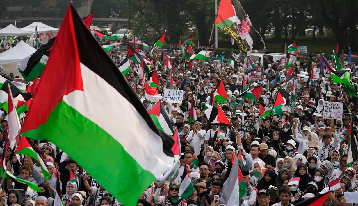 Para pengunjuk rasa meneriakkan slogan-slogan sementara yang lain melambaikan bendera Palestina dalam sebuah aksi unjuk rasa untuk mendukung rakyat Palestina di Gaza, di depan Kedutaan Besar Amerika Serikat di Jakarta, Sabtu, 1 Juni 2024. (AP Photo/Achmad Ibrahim)
