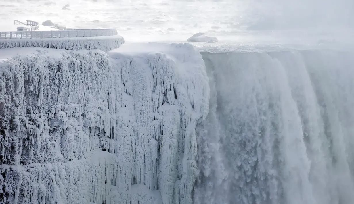 Es dan air mengalir di tepi Horseshoe Falls dari Air Terjun Niagara di Ontario, Kamis (31/1). Saat AS dilanda suhu yang lebih dingin dari Antartika, temperatur di Kanada juga menurun menjadi minus 18 derajat Celcius (Tara Walton/The Canadian Press via AP)