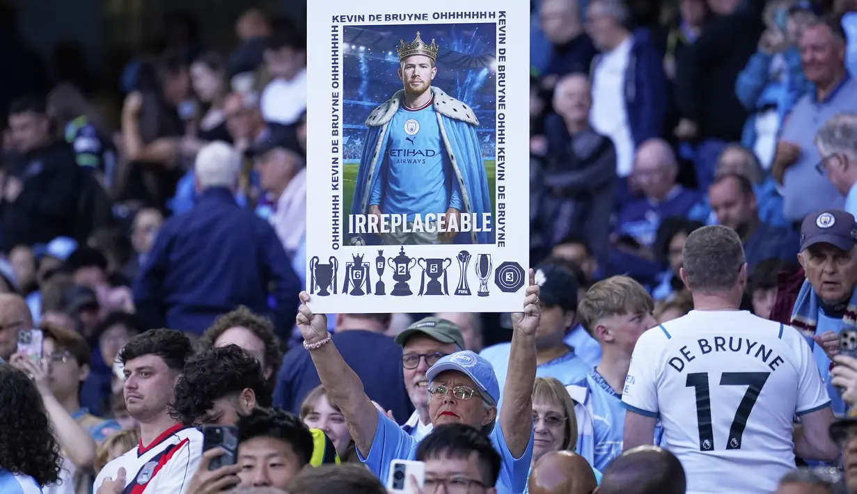 Pendukung Manchester City mengangkat poster bertuliskan "Tak Tergantikan" untuk perpisahan Kevin De Bruyne saat laga pekan ke-37 Liga Inggris 2024/2025 melawan Bournemouth di Etihad Stadium, Manchester, Inggris, Selasa (21/05/2025) waktu setempat. (AP Photo/Dave Thompson)