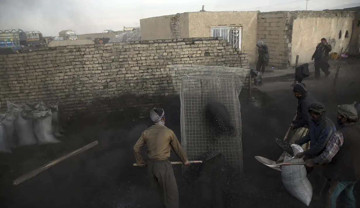 Sejumlah buruh Afghanistan bekerja di pasar arang di pinggiran Kabul, Afghanistan (18/12/2019). Di musim dingin, harga kayu dan arang naik di antara semua kebutuhan lain untuk warga Afghanistan. (AP Photo / Rahmat Gul)