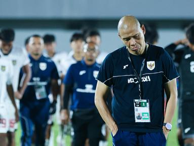 Pelatih Timnas Indonesia U-17, Nova Arianto tertunduk lesu usai memimpin tim asuhannya bertanding melawan China dalam laga uji coba di Indomilk Arena, Tangerang, Banten, Minggu (8/2/2026). (Bola.com/M Iqbal Ichsan)