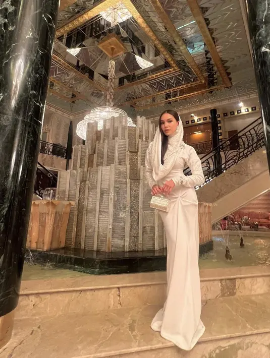 Aksen kerudung yang dipadukan dengan wrapped dress. menhadirkan kesan anggun yang tak terbatahkan. [Foto: Instagram/Karraminah]