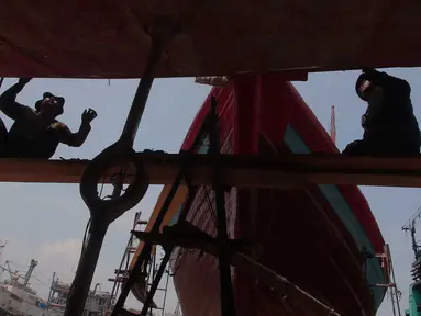 Pekerja memperbaiki bagian lambung kapal ikan di Unit Docking Kapal Perikanan kawasan Muara Angke, Jakarta, Senin (9/11/2015). Perawatan tersebut dilakukan setiap 6 bulan untuk menjamin keamanan dan keselamatan para nelayan (Liputan6.com/Angga Yuniar)