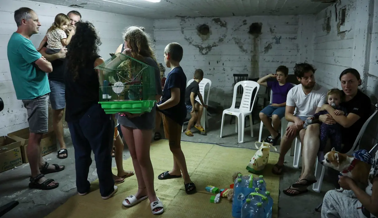 Warga Israel berlindung di tempat perlindungan saat sirene membunyikan peringatan akan adanya roket yang ditembakkan dari jalur Gaza di Tel Aviv, Israel, Sabtu (14/10/2023). (AP Photo/Gideon Markowicz)