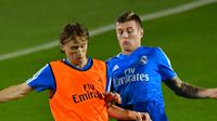 Gelandang Real Madrid, Luca Modric berebut bola dengan Toni Kroos saat latihan jelang menghadapi Kashima Antlers pada semifinal Piala Dunia Antarklub 2018 di stadion New York University Abu Dhabi, Uni Emirat Arab (17/12). (AFP Photo/Giuseppe Cacace)
